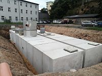 detailní reference, Řešení odvodnění zpevněných parkovacích ploch na ulici Pastýřská v Liberci. Osazeno betonovou retenční nádrží s vírovým regulátorem odtoku a odlučovačem ropných látek, db betonové jímky